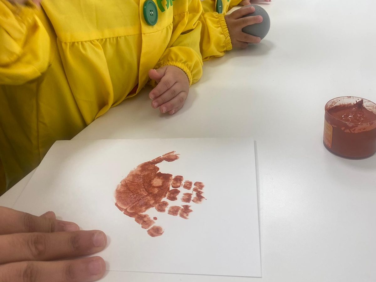 Huella de una mano pintada en marrón sobre papel