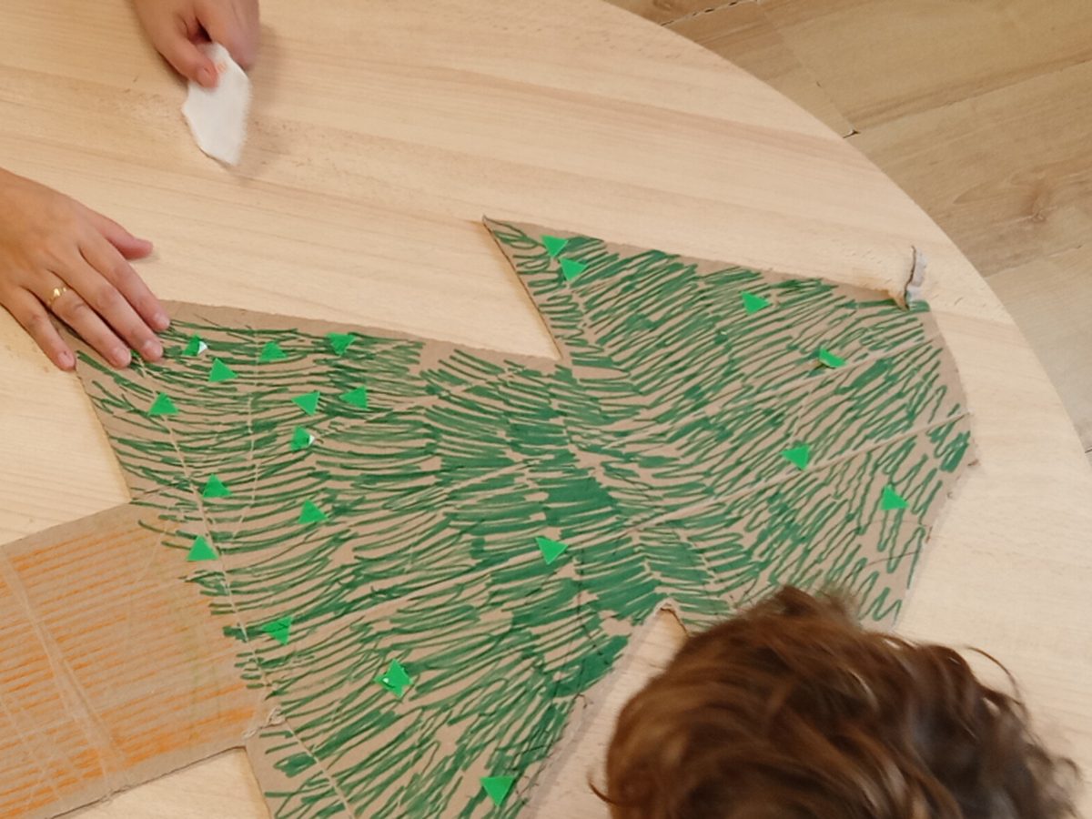 Árbol de Navidad hecho con huellas verdes sobre una mesa