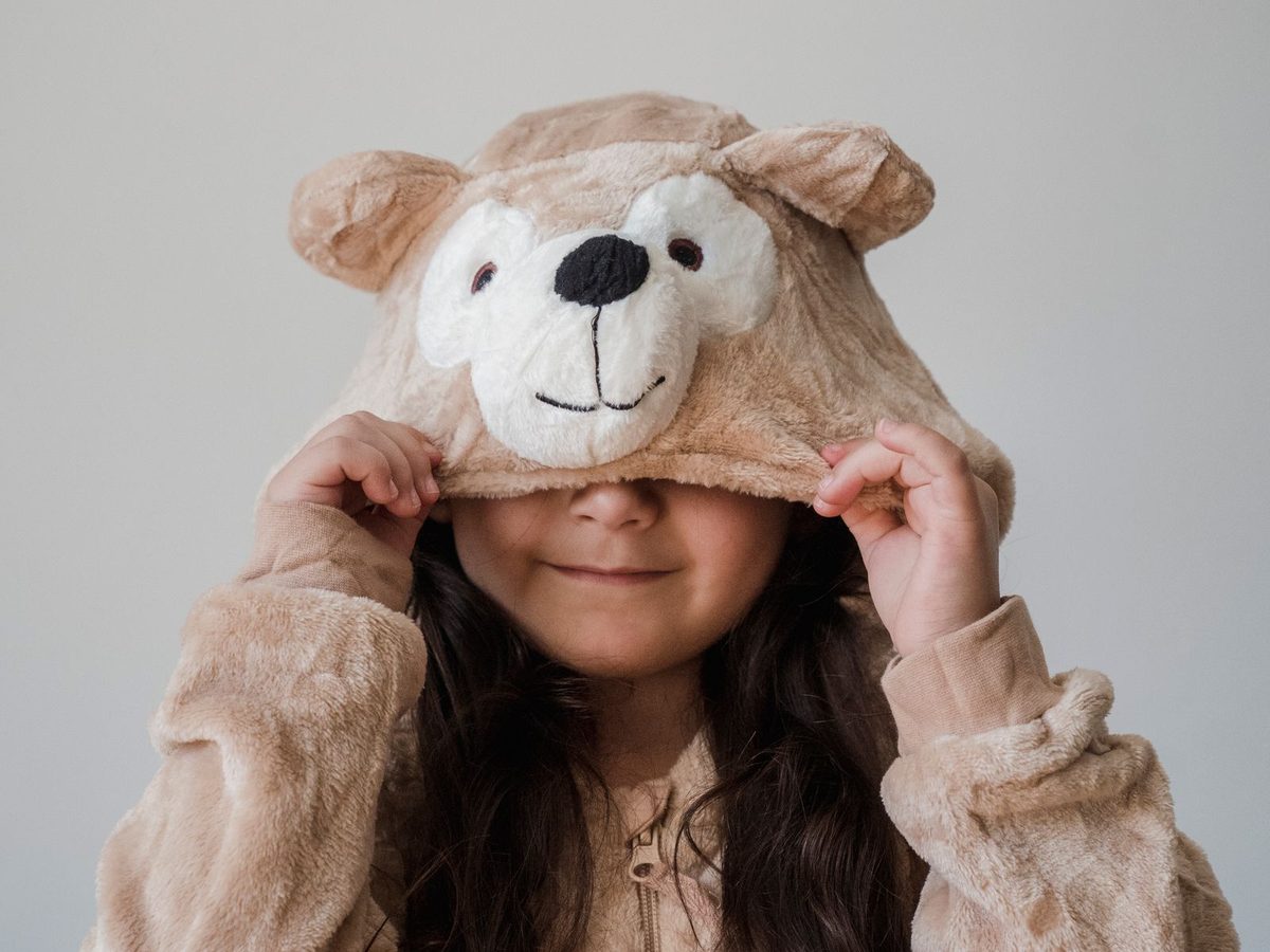 Niña jugando con un disfraz de oso