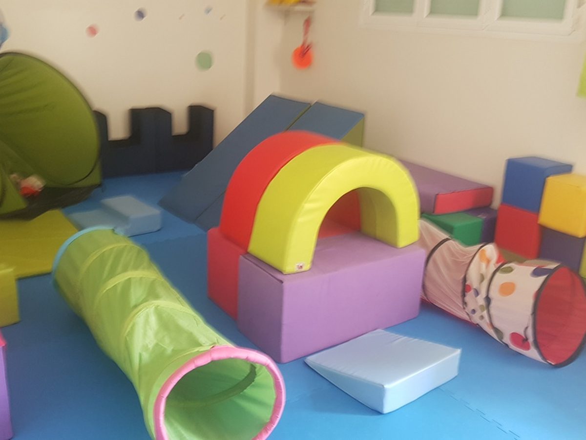 Sala de psicomotricidad con túneles, arcos y bloques blandos