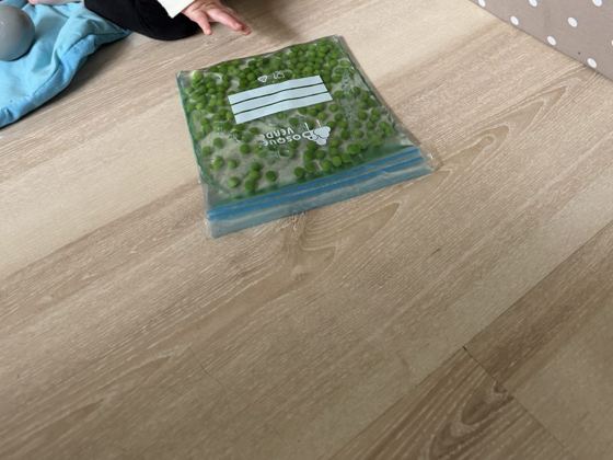 Bolsa sensorial verde con gel y bolitas sobre el suelo