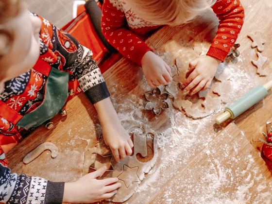 Niños cortando galletas de Navidad con moldes