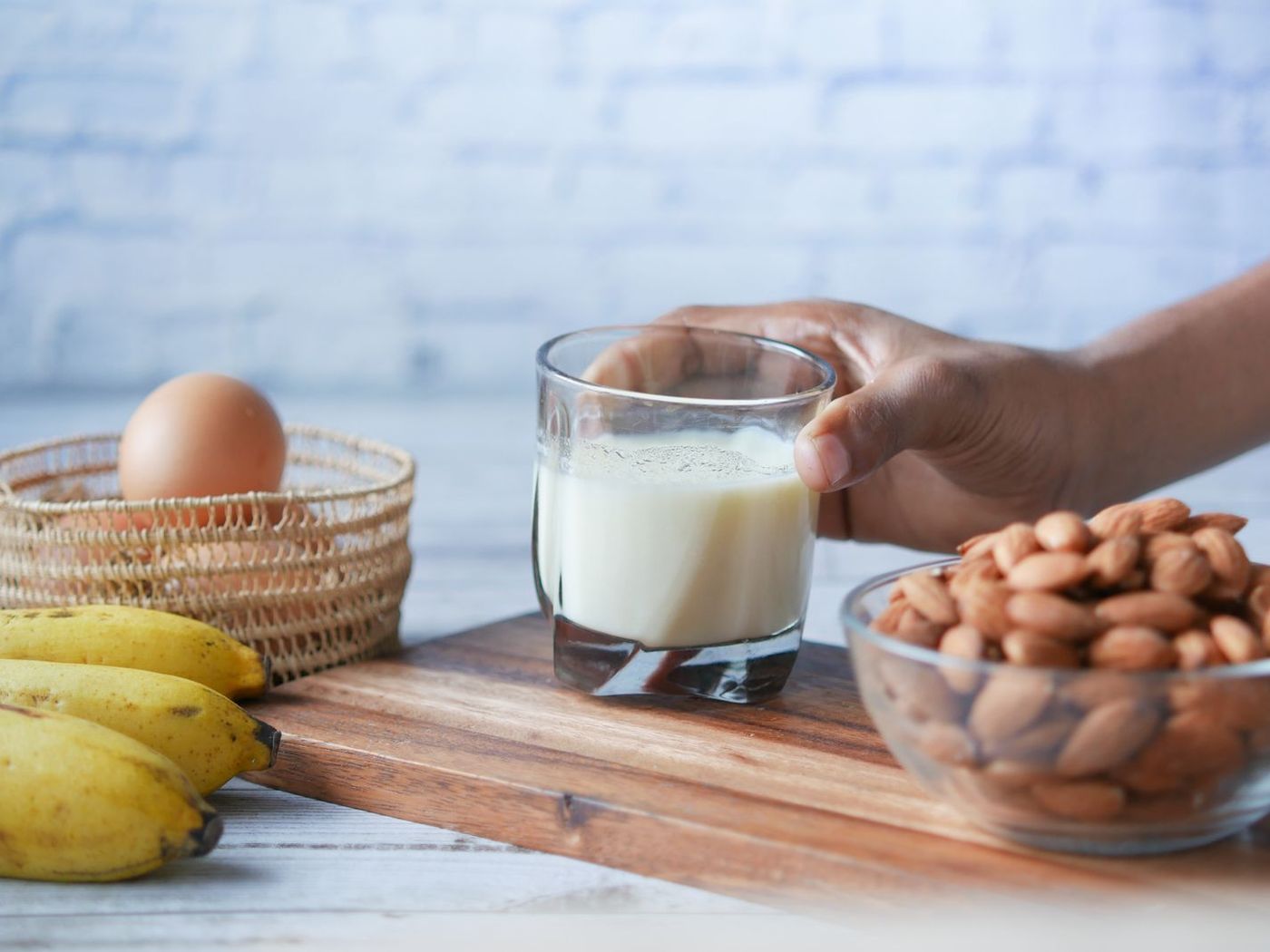 Huevos, un vaso de leche, pescado y frutos secos sobre una mesa de cocina