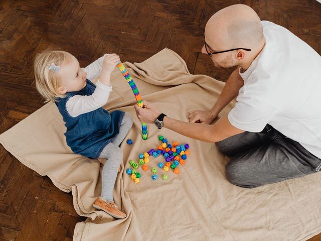 Padre jugando en el suelo con su hijo pequeño